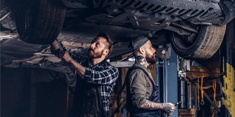 Image of 2 diesel mechanics repairing a truck