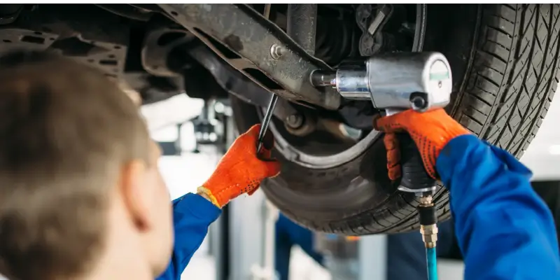 Image of a mechanic repairing a truck's suspension